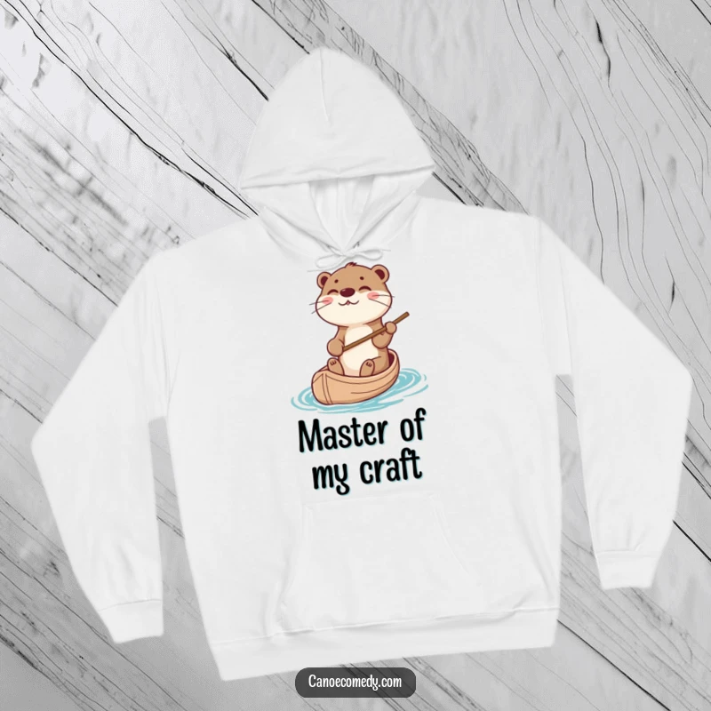 Playful otter character steering a canoe with a stick, featured on a cozy hoodie, making it a funny outdoor gift.