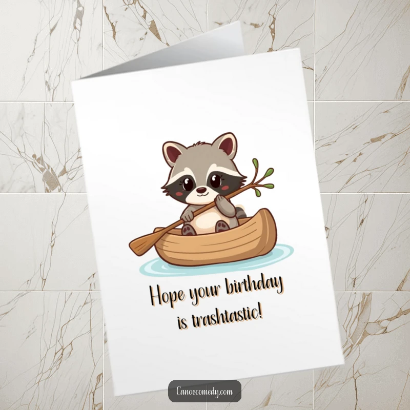 Funny Free Printable Birthday Card: Kawaii raccoon cleverly steering a canoe with a twig, a mischievous and charming DIY gift.